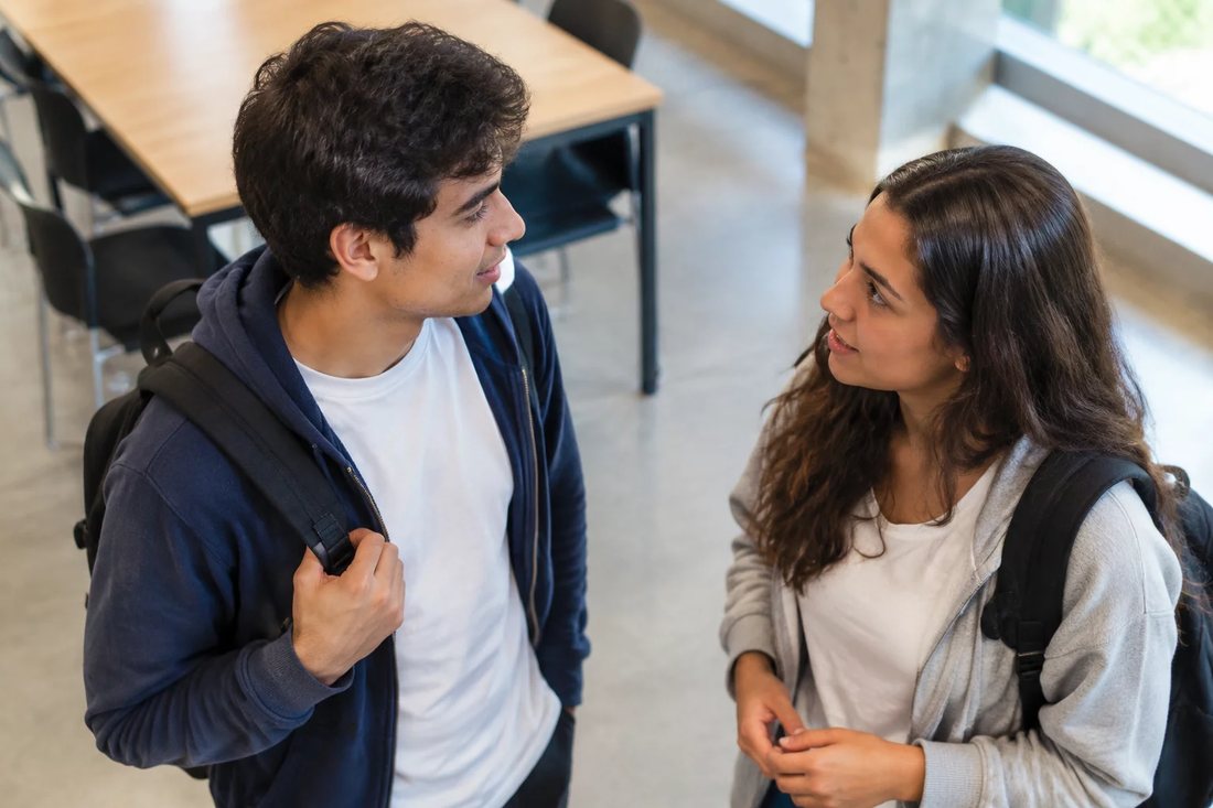 Grupo reduzido em volta de uma mesa comprida lendo teses impressas